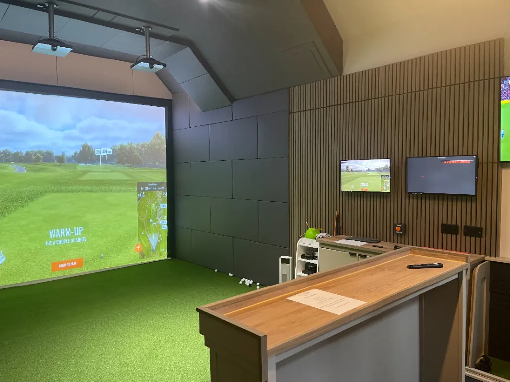 Golf simulator bay with TrackMan iO showing driver swing clearance
