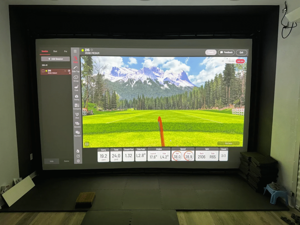 Uneekor EYE XO2 SwingBay simulator screen showing ball flight tracking data with mountain course in background